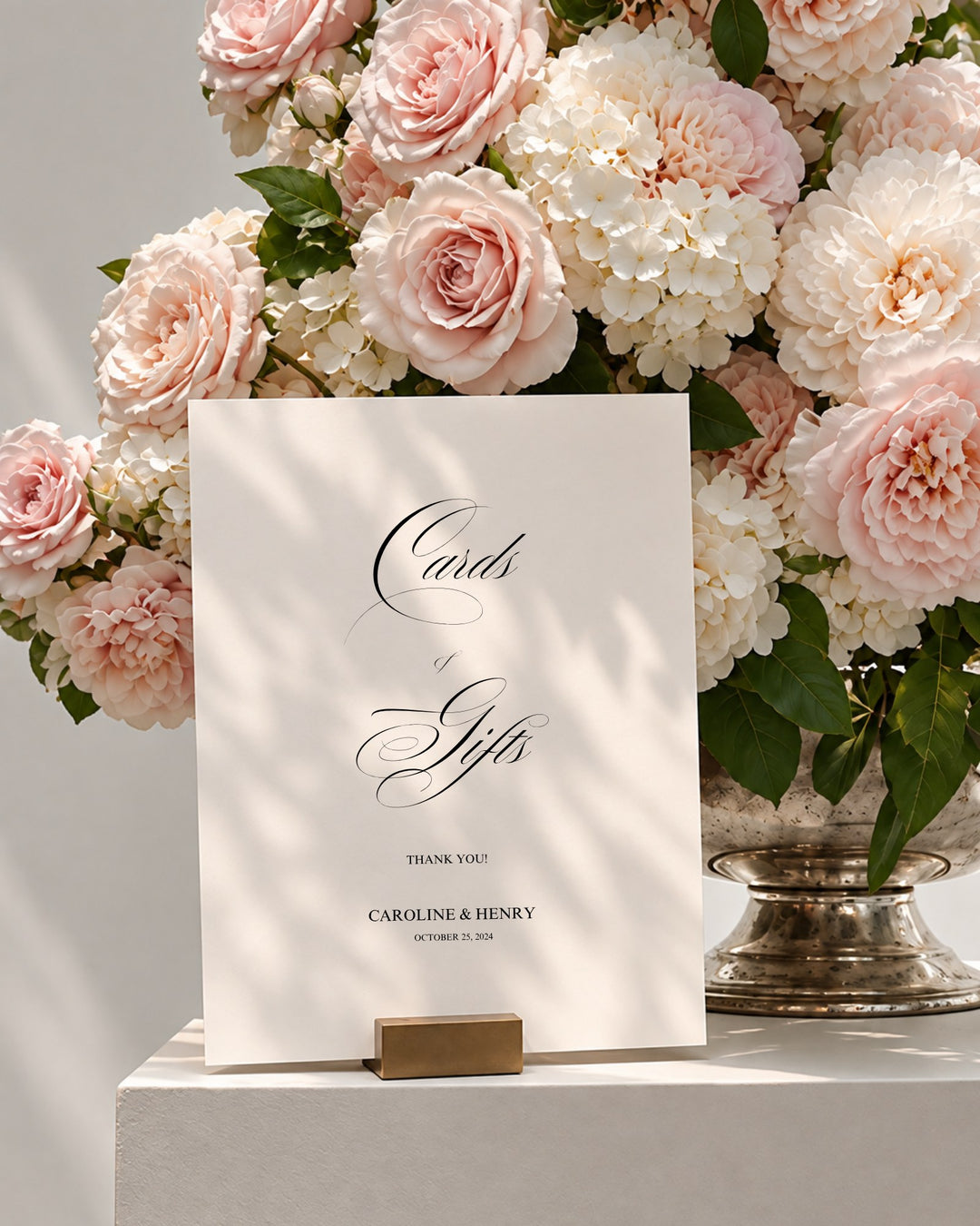 Florence acrylic wedding cards and gifts sign in a gold holder beside pink roses and white hydrangeas
