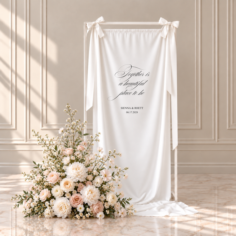 Florence fabric custom quote wedding sign: together is a beautiful place to be, with the couple's names and wedding date, hanging from a white frame with ribbon bows beside blush and ivory flowers