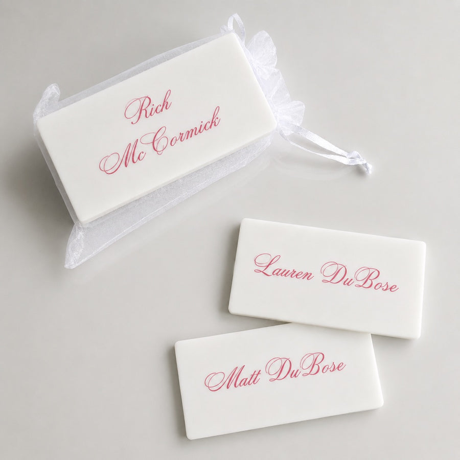 White acrylic place cards with names in pink script