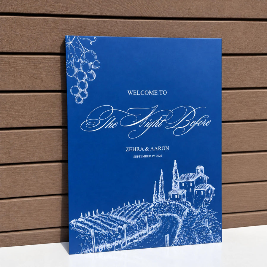 Royal blue welcome sign for The Night Before with a white vineyard illustration